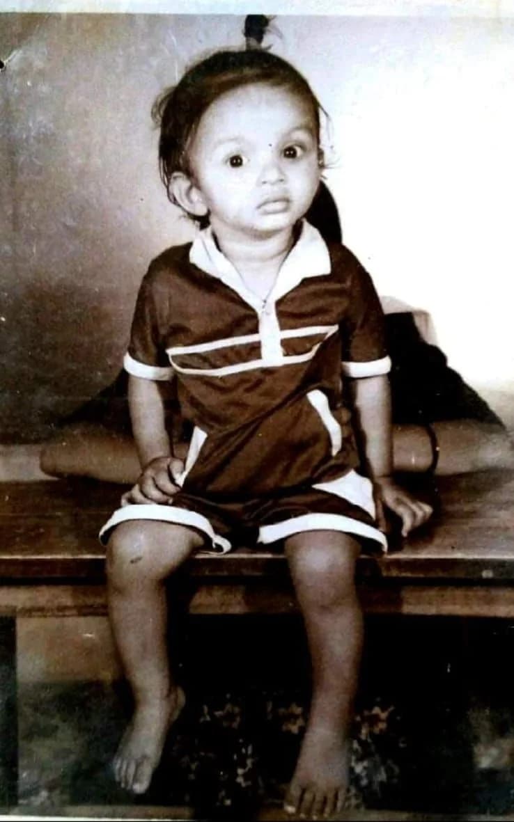 Swami G at the age of two, sitting on a wooden bench, in an old black-and-white photo